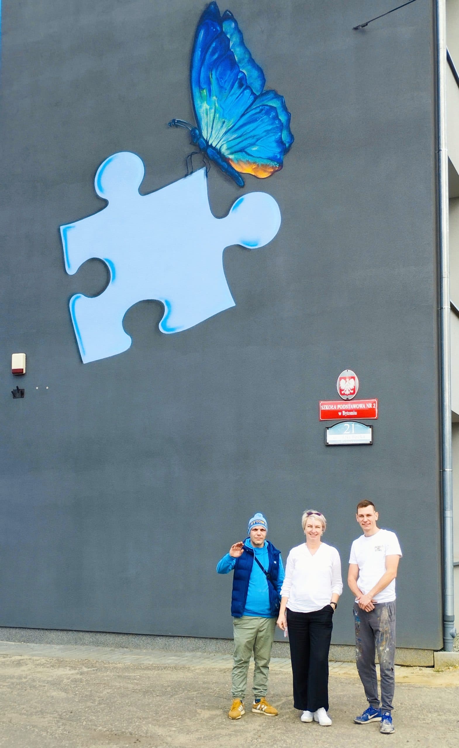 Mural z niebieskim motylem i puzzlem na elewacji Szkoły Podstawowej nr 2 w Bytomiu